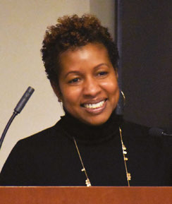 Woman in picture in black at the podium image.