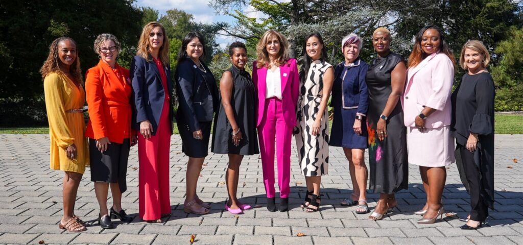 A group of professional women, elegantly dressed, posing for a photograph, radiating confidence.