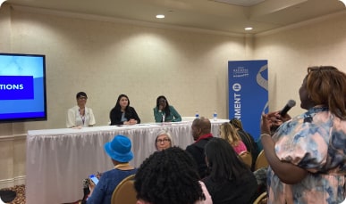 Women actively participating in a conference discussion.
