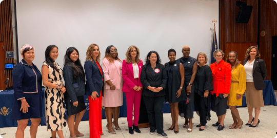 A group of professional women standing together, posing for a picture.