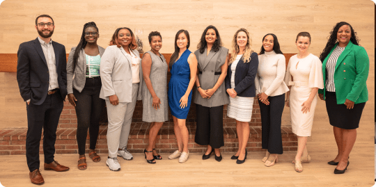 A group of professional men and women standing together and posing for a picture.